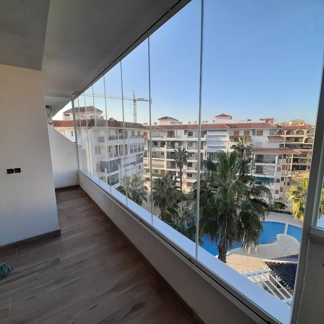 Cerramiento de terraza con cristal y suelo de parquet